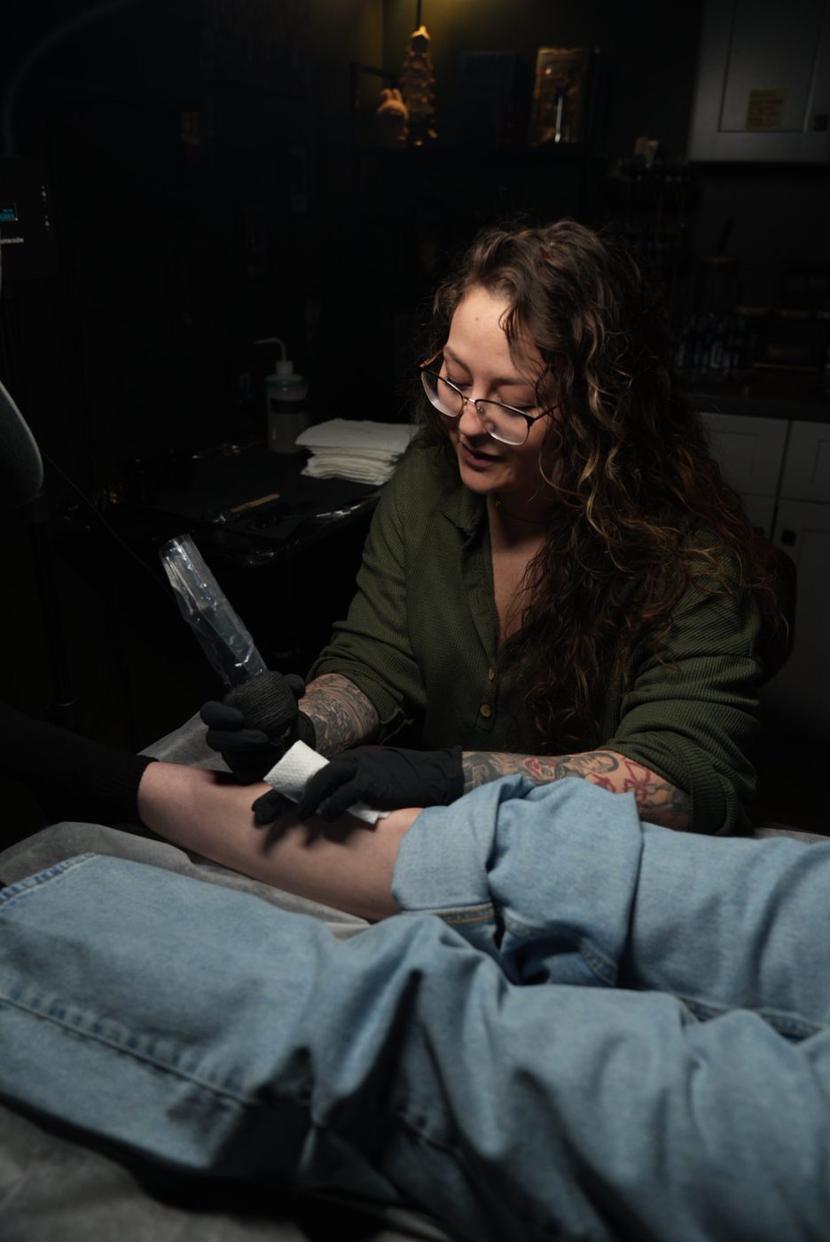 Anna tattooing a forearm