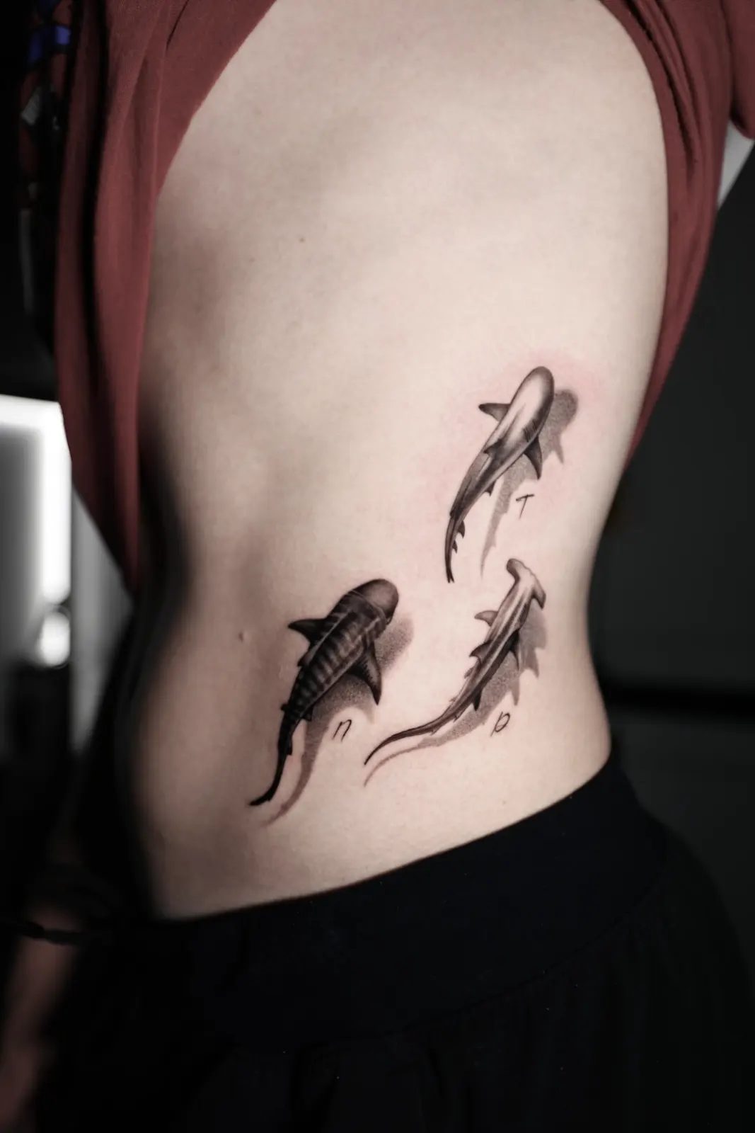 Two fish swimming up the ribs, fine black and grey