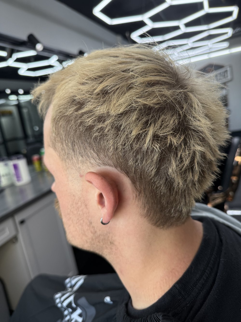 Blond textured mullet with a taper, from behind