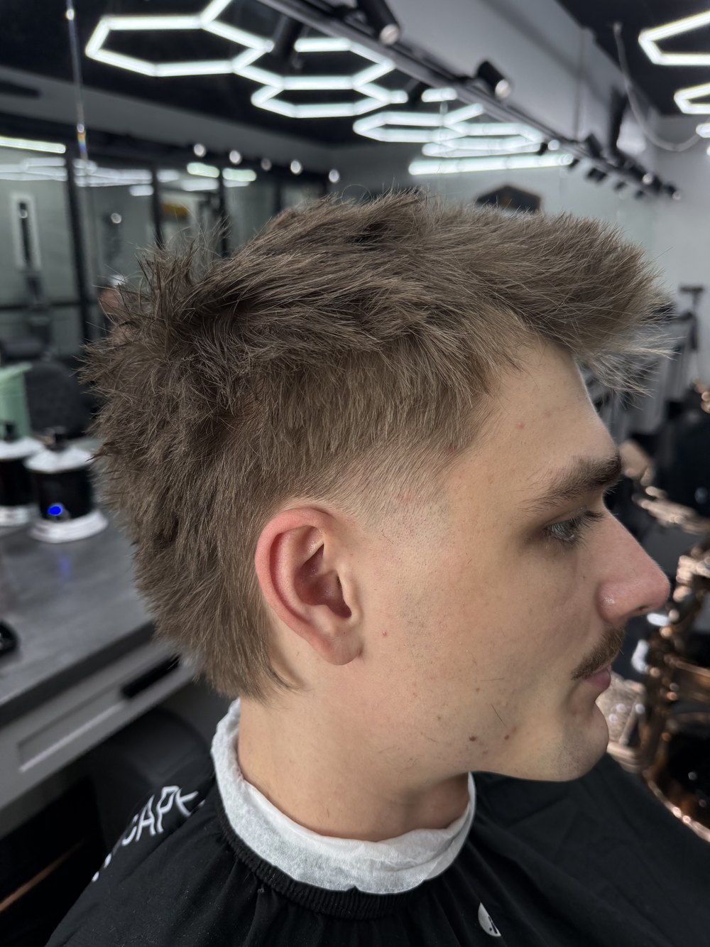 Textured faux-hawk with a low taper, side view