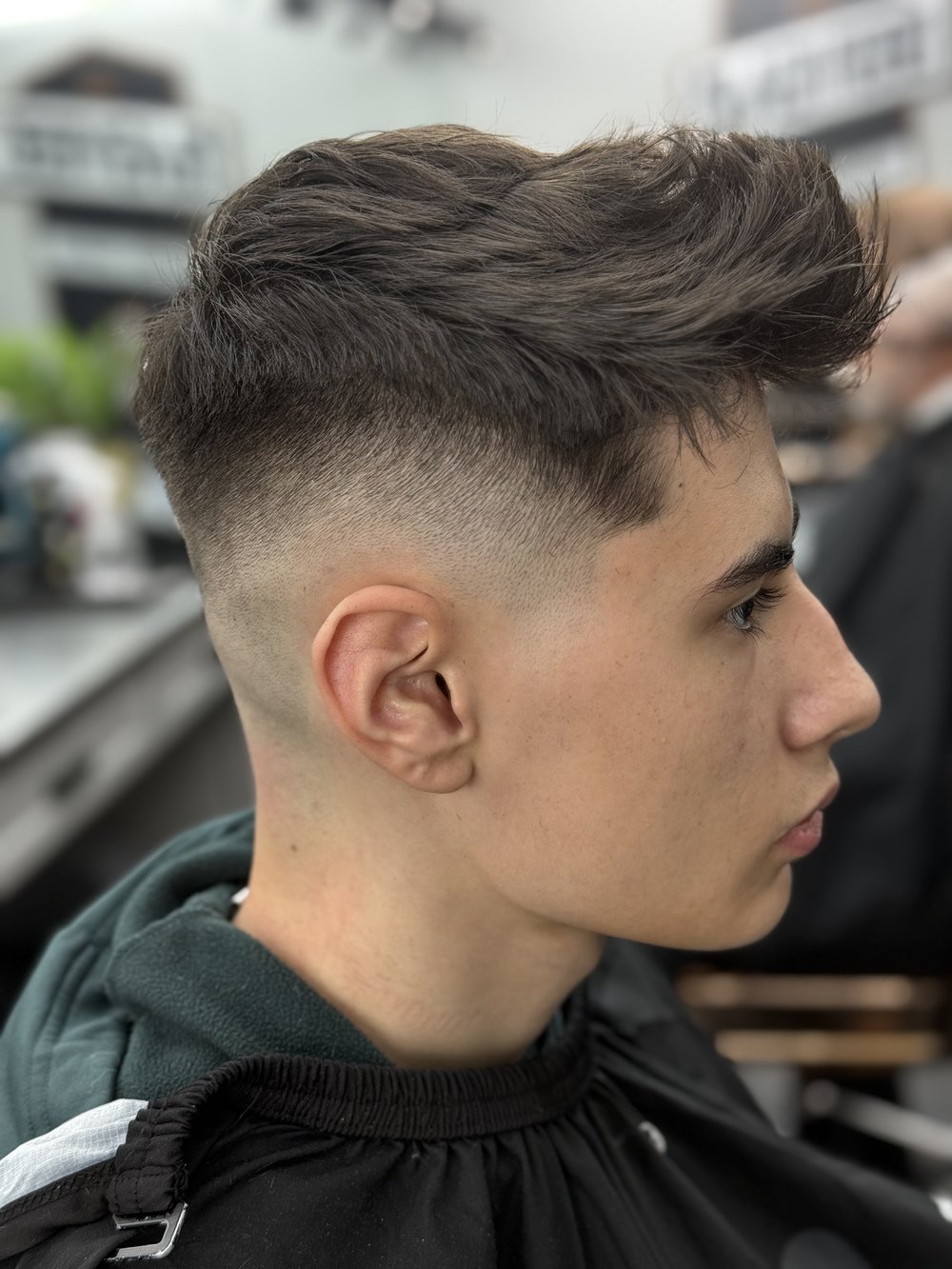 Swept-back quiff with a high skin fade
