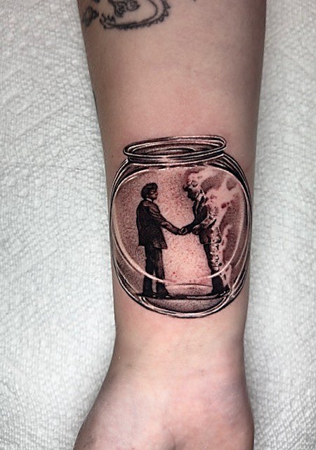 Two figures shaking hands inside a jar, wrist