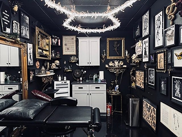 Dale’s room at Blvck Rose — black walls, framed flash and gold frames