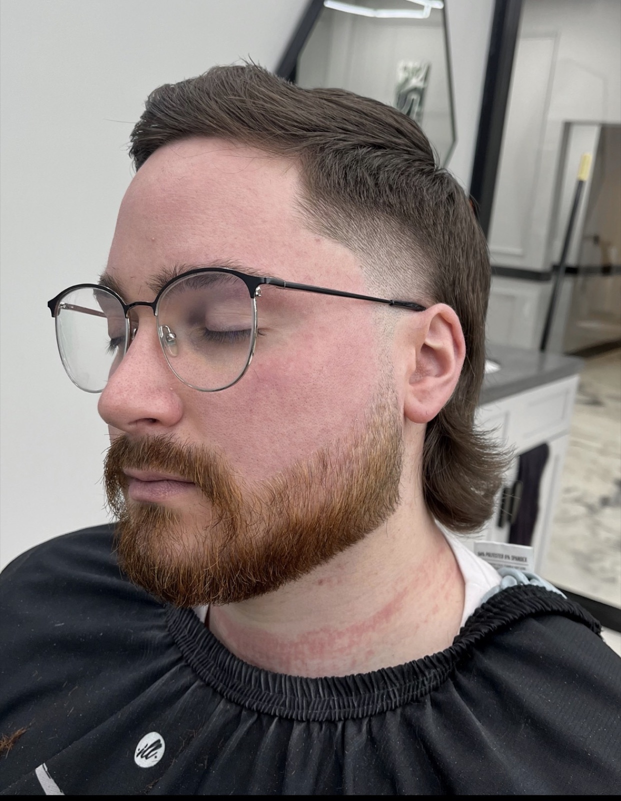 Modern mullet with a sculpted mustache and beard