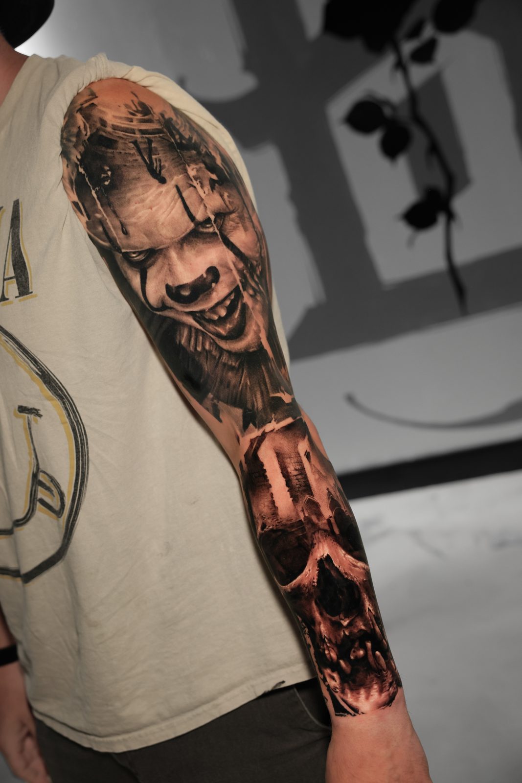 Grinning clown above a skull, full sleeve
