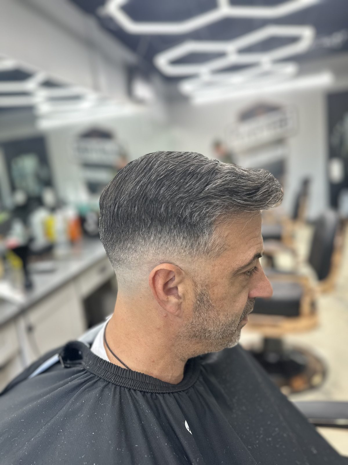 Grey side part with a blended taper