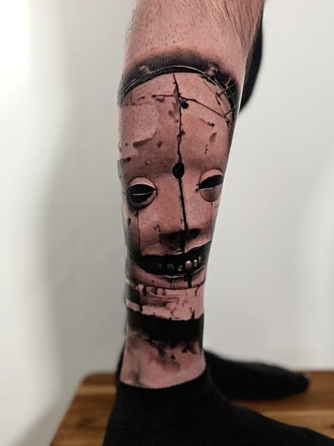 Cracked porcelain doll face down the calf