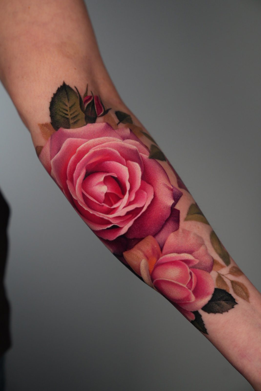 Two pink roses along the forearm