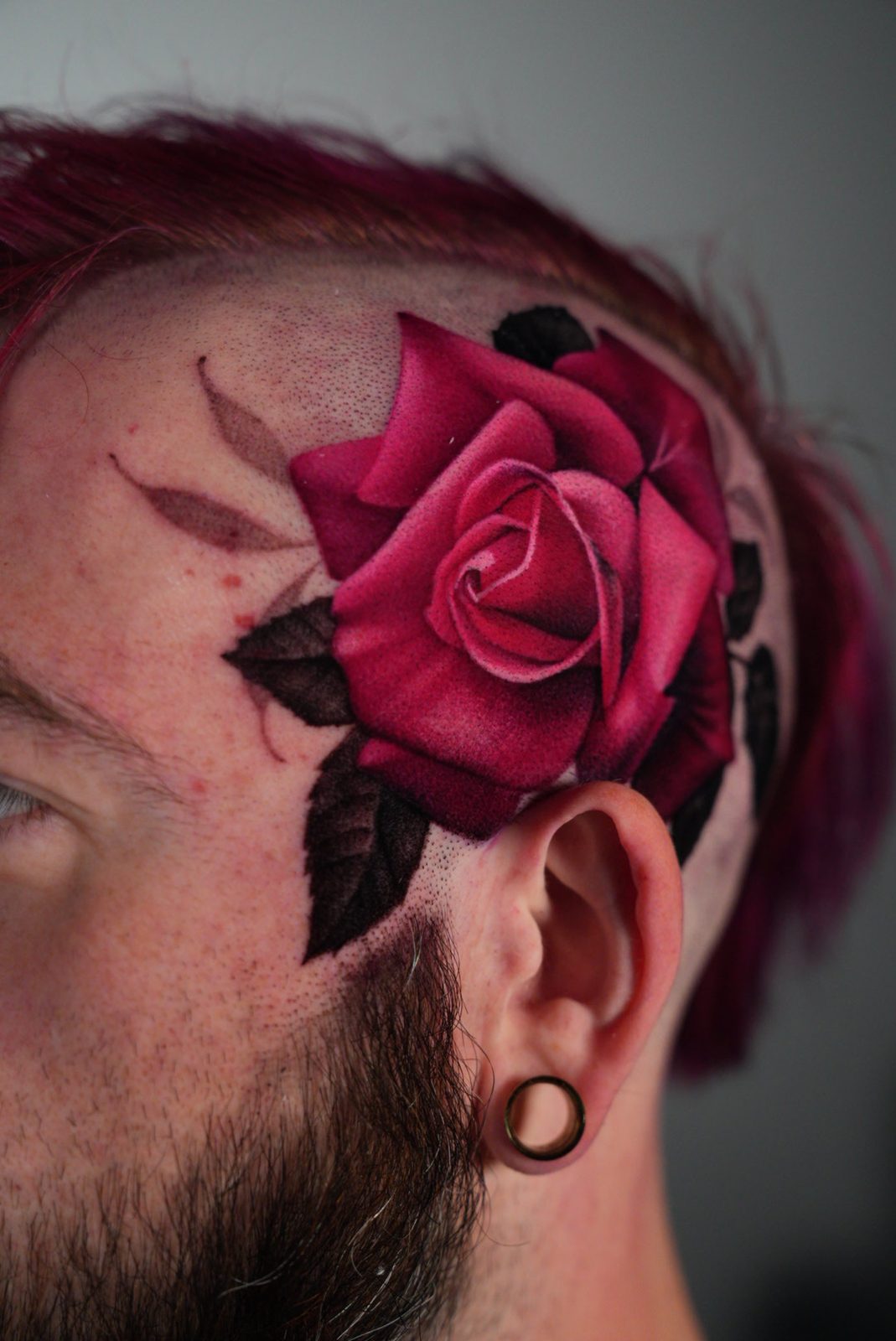 Deep red rose behind the ear